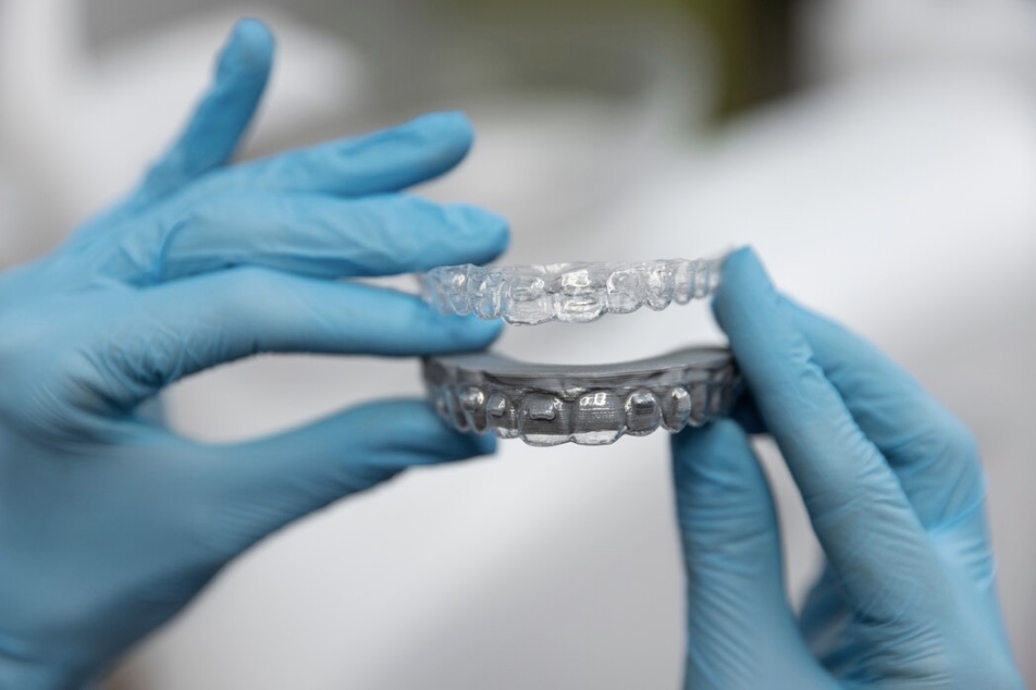 Aparelho invisível sendo manuseado por um dentista